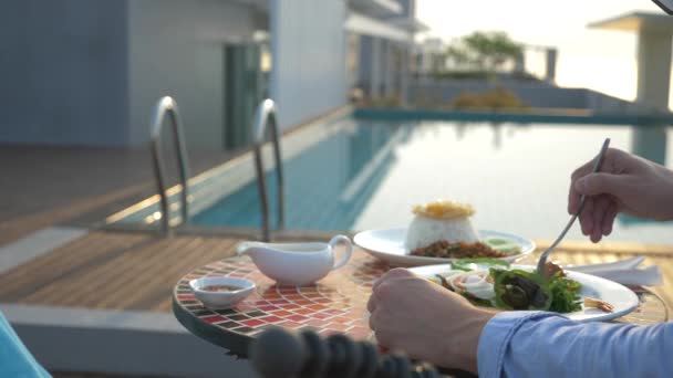 La sopa de camarones es un plato tailandés con un sabor agrio y picante. El hombre se está comiendo a Tom Yam en una mesa junto a la piscina. 4k, cámara lenta, primer plano. concepto de turismo turístico — Vídeos de Stock