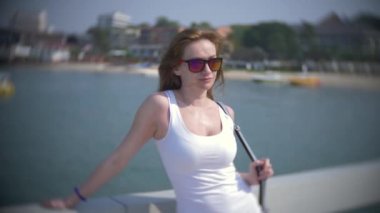 bir kadın güneş gözlüğü iskelede duran tekneler izliyor. 4k, arka plan, yavaş hareket bulanıklığı