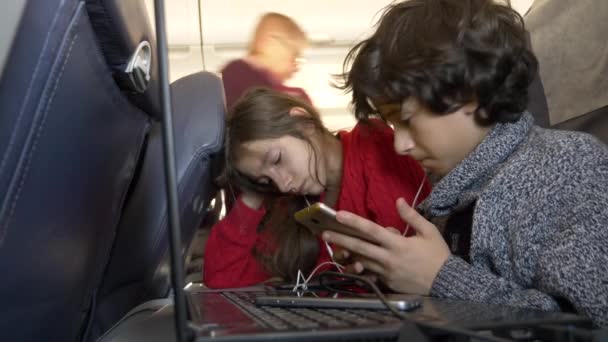 4k, primo piano, bambini, passeggeri usano il telefono in aereo contro l'oblò . — Video Stock