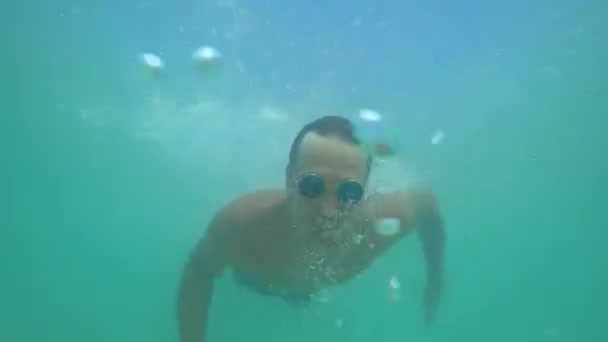 En man dyker in i ett kristallklart hav i en mask 4k — Stockvideo