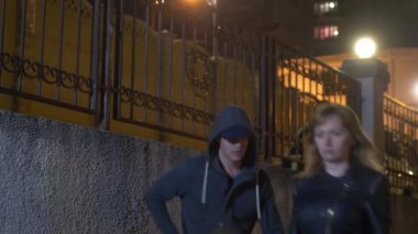 Erkek, bir kadını tehdit de çantasını, karanlık bir sokakta alır. Geceleyin