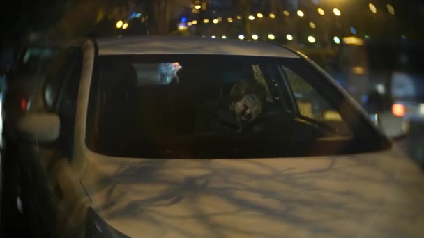 Mujer con chaqueta Se sienta en el coche llorando. noche y lluvia, 4k, desenfoque de fondo — Vídeo de stock