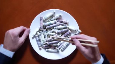 Eller bir işadamı ile chopsticks ve Doları alır. dolar yeme. 4k.