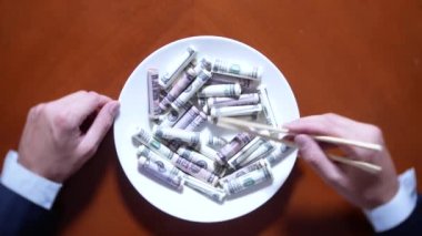 Eller bir işadamı ile chopsticks ve Doları alır. dolar yeme. 4k.