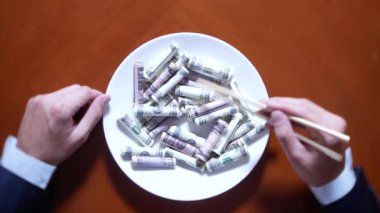 Eller bir işadamı ile chopsticks ve Doları alır. dolar yeme. 4k.