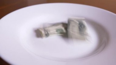 birisi bir tabak dolar atar. dolar ye. 4k.