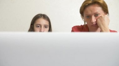 Anne ve kızı bir ödev bir dizüstü bilgisayar üzerinde birlikte çalışma. Online eğitim online Okulu. 4k.