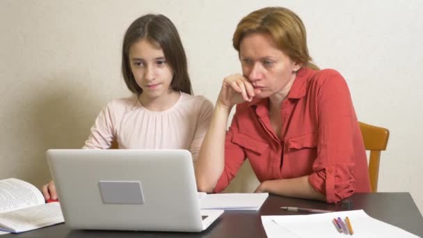 Мати і дочка працюють разом на домашньому робочому місці на ноутбуці. онлайн навчання, онлайн-школа. 4k . — стокове відео