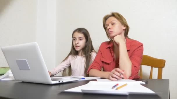Mãe e filha trabalhando em uma lição de casa juntas em um laptop. aprendizagem online, escola online. 4k . — Vídeo de Stock