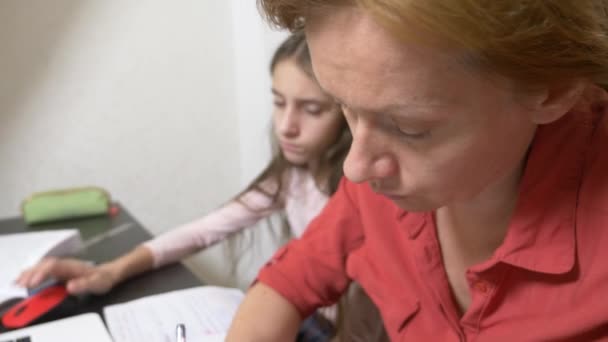Mãe e filha trabalhando em uma lição de casa juntas em um laptop. aprendizagem online, escola online. 4k . — Vídeo de Stock