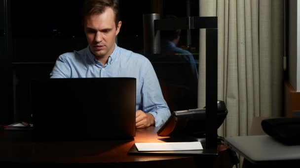 Negócio, excesso de trabalho, prazo e conceito de pessoas - um homem trabalhando em um laptop à noite. 4k — Vídeo de Stock