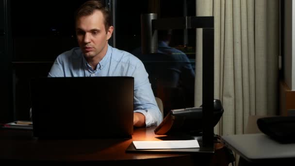 工作, 过度劳累, 最后期限和概念的人-一个人在笔记本电脑在晚上。4k — 图库视频影像