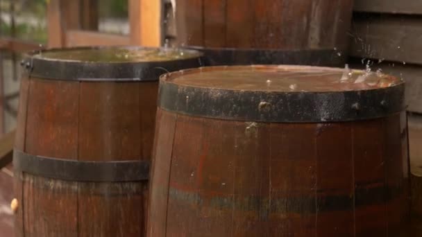 Barricas de cerveza de roble en la calle bajo la lluvia. 4k, cámara lenta — Vídeo de stock