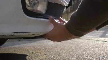hasarlı araç arıyorum. adam sarışın araba hasar bir kazadan sonra inceler.