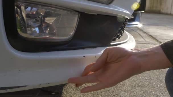 Mirando un vehículo dañado. Mujer rubia inspecciona daños en el coche después de un accidente — Vídeo de stock