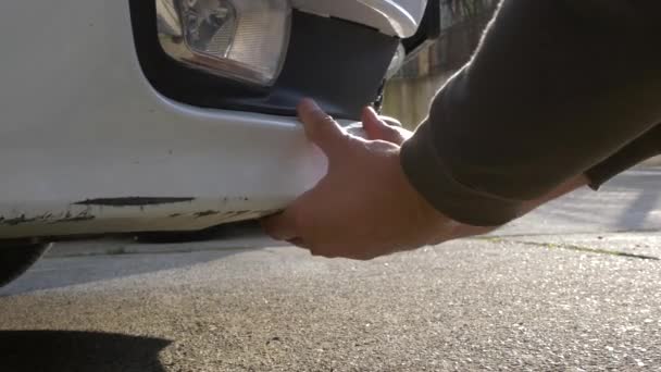 Regardant un véhicule endommagé. homme blonde inspecte les dommages de voiture après un accident — Video