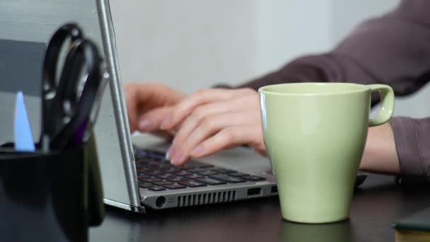 Молодая женщина потягивает чай на ноутбуке во время работы в офисе. макро, 4k — стоковое видео
