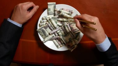 Eller bir işadamı ile chopsticks ve Doları alır. dolar yeme. 4k.