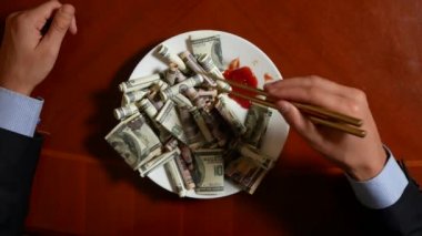 Eller bir işadamı ile chopsticks ve Doları alır. dolar yeme. 4k.