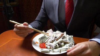 ceket ve kravat adam Doları rulo çubukla yemek. dolar ye. 4k.