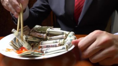 ceket ve kravat adam Doları rulo çubukla yemek. dolar ye. 4k.