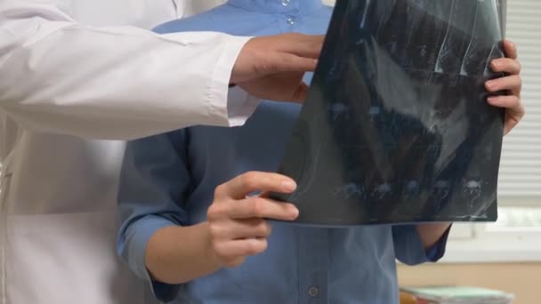 Преследование в больнице. врач обращается к коллеге во время анализа результатов магнитно-резонансной терапии. 4k, slow motion — стоковое видео