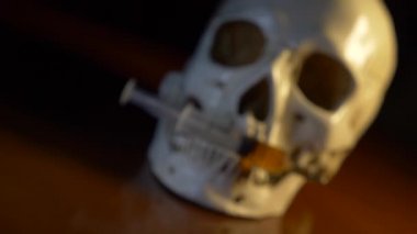 Kafatası ve şırınga sarımtırak sıvı. kavram uyuşturucu. 4k, dolly ateş