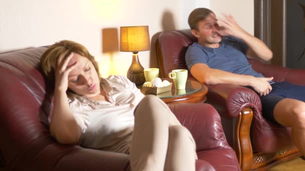 Malam keluarga, suami dan istri duduk di kursi di rumah mereka dan mencari tahu hubungan mereka. 4k — Stok Video