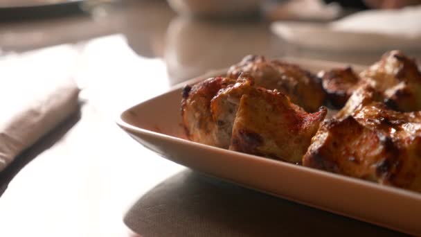 Fermeture de la viande rôtie couchée sur une assiette blanche avec des légumes verts sur une table au ralenti, 4k, vapeur de viande chaude — Video