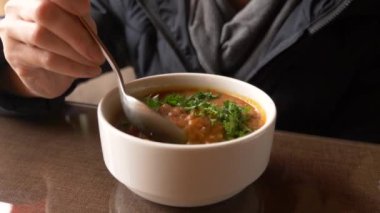 Bir kase sıcak chili con carne buğulaması kapatın. lobio. bir adam sıcak bir tabak fasulye yiyor. 4k, buhar sıcak yemek