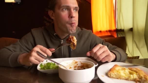 レストランで男がフォーク、4 k、スローモーション撮影で熱い肉を食べる — ストック動画