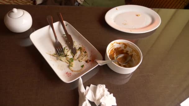 フォーク、スプーン、テーブル、4 k を食べた後の食品廃棄物を空の汚れた白皿 — ストック動画