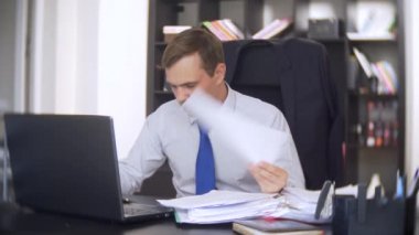 belgeler, inceden inceye gözden geçirmek bir işadamı, bir dizüstü bilgisayar kullanarak frowns, ofiste acil bir görev yapmaz, yeterli zaman değil 4k. ofis çok sıcak, Klima çalışmıyor