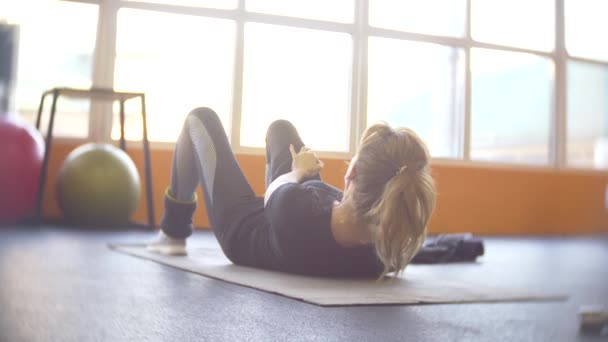 Una donna che lavora in palestra. 4k, sfocatura dello sfondo — Video Stock