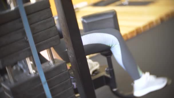 Una mujer haciendo ejercicio en el gimnasio. 4k, desenfoque de fondo — Vídeo de stock