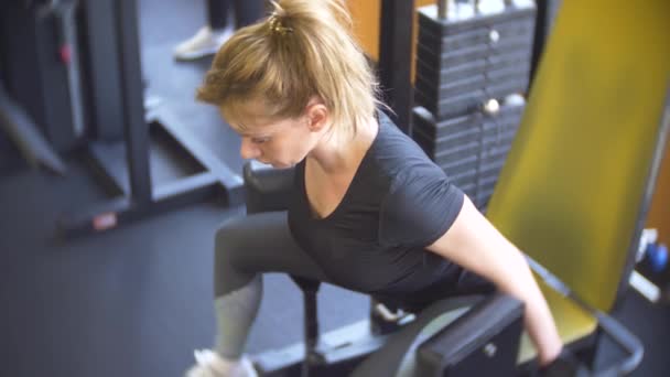 Vrouw trainen in de sportschool. 4k, achtergrond vervagen — Stockvideo