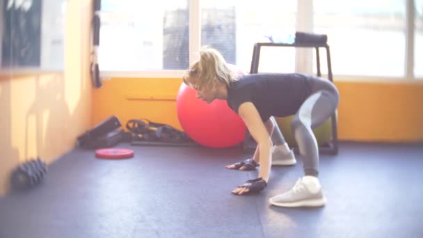 Жінка працює в спортзалі. 4k, розмивання тла — стокове відео