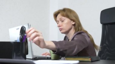 Genç bir kadın çay bir dizüstü bilgisayar üzerine dökülür. ofiste çalışıyor. Ağır çekim silah, 4 k