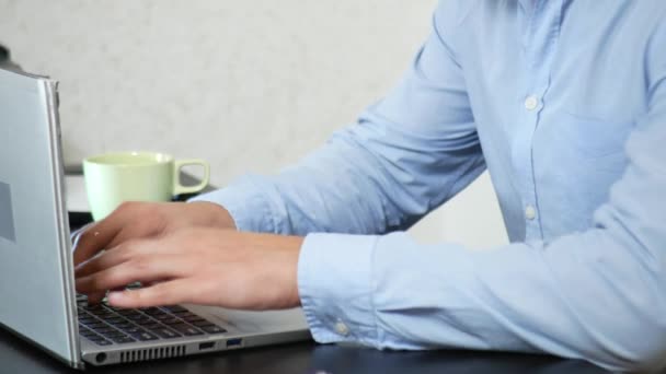 Mladý muž naléval čaj na laptop. práce v kanceláři, 4 k detail, — Stock video