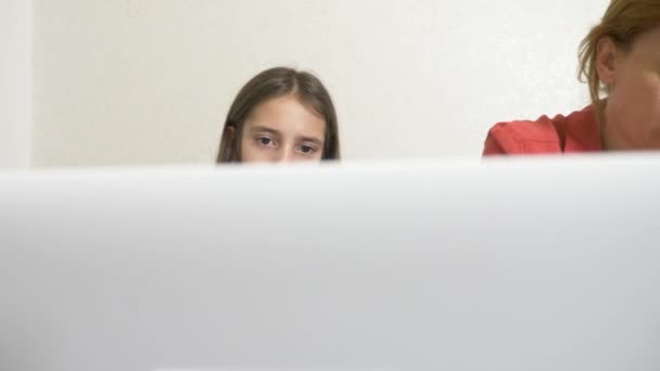 Anne ve kızı bir ödev bir dizüstü bilgisayar üzerinde birlikte çalışma. Online eğitim online Okulu. 4k. — Stok video