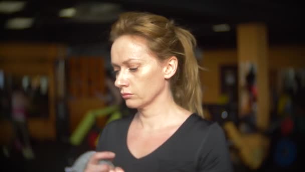 Una mujer haciendo ejercicio en el gimnasio. 4k, desenfoque de fondo — Vídeos de Stock