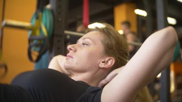 Una mujer haciendo ejercicio en el gimnasio. 4k, desenfoque de fondo — Vídeos de Stock