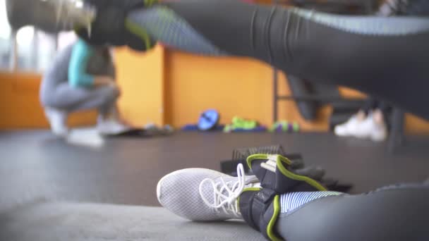 Una mujer haciendo ejercicio en el gimnasio. 4k, desenfoque de fondo — Vídeo de stock