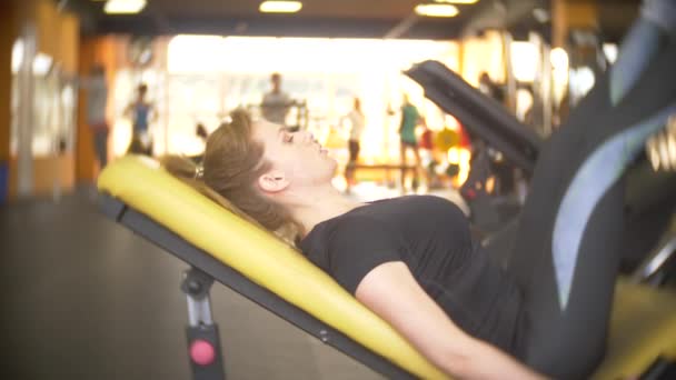 Una mujer haciendo ejercicio en el gimnasio. 4k, desenfoque de fondo — Vídeos de Stock