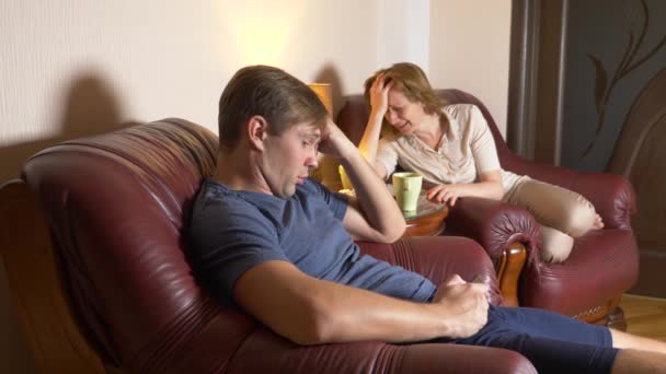 家庭之夜, 丈夫和妻子坐在他们家的椅子上, 找出关系。4k — 图库视频影像