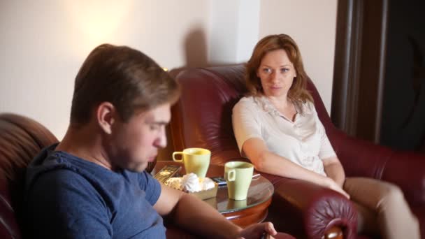 Семейный вечер, муж и жена сидят в кресле в своем доме и выясняют отношения. 4k — стоковое видео
