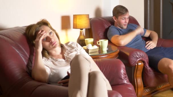 Noche familiar, marido y mujer se sientan en una silla en su casa y averiguar la relación. 4k — Vídeos de Stock