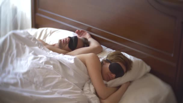 Casal de máscaras para dormir chateado, deitado na cama, problema. 4k — Vídeo de Stock