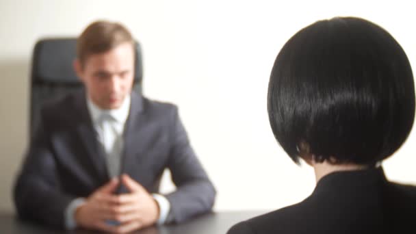 Un hombre de traje le hace preguntas a una morena en una entrevista. 4k. entrevista. contratación de personal — Vídeo de stock