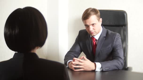 Un homme en costume pose des questions à une femme brune lors d'une interview. 4k. entretien. recrutement — Video